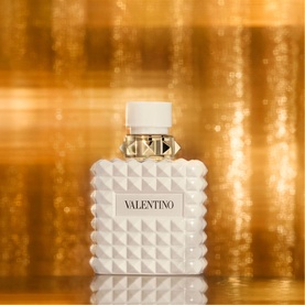 Valentino Born In Roma Ivory Donna Eau de Parfum 100ml, white quilted bottle with gold stud detail and white cap, golden bokeh background