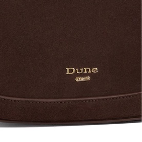Dune Direction Saddle Shoulder Bag in brown suede, close-up of gold-tone embossed brand logo on front panel