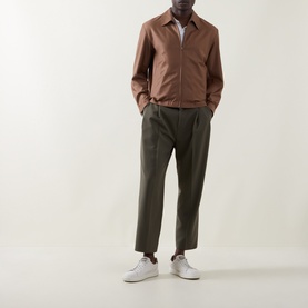 Model wearing Boss Black Casual Wing Zip Jacket in medium brown wool, styled with olive tapered trousers and white trainers.