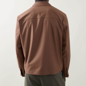 Model wearing Boss Black Casual Wing Zip Jacket in medium brown, rear view, showing point collar, long sleeves, and straight hem. Styled with olive