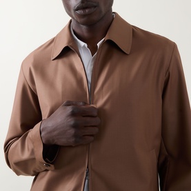 Model wearing Boss Black Casual Wing Zip Jacket in medium brown, featuring point collar and concealed zip fastening, styled over white shirt.
