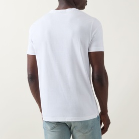 Model wearing Boss Black Casual white crew neck T-shirt, back view, styled with light blue jeans.