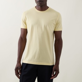 Model wearing Boss Black Casual Taut Logo T-Shirt in Beige Overflow, crew neck, short sleeves, styled with navy trousers