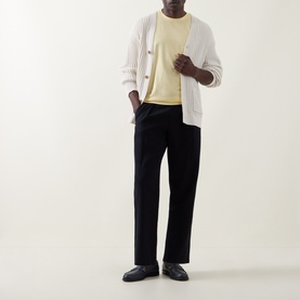 Model wearing Boss Black Casual Taut Logo T-Shirt in Beige Overflow, styled with a white cardigan and black tailored trousers.