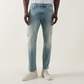 Model wearing Boss Black Casual Classic Fit Straight-Leg Jeans in turquoise light wash with authentic fading, styled with white trainers and white