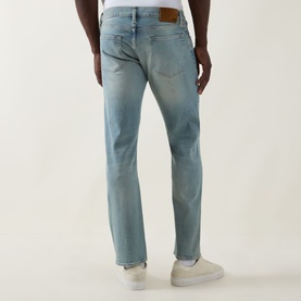 Model wearing Boss Black Casual Classic Fit Straight-Leg Jeans in turquoise/aqua light wash, rear view showing logo patch and straight leg, styled