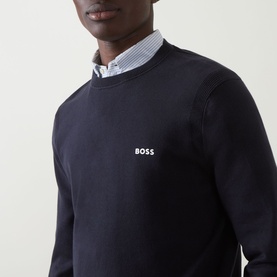 Model wearing Boss Green Label dark blue cotton crew neck knit, styled with a light blue striped shirt collar visible at neckline.