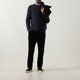 Model wearing Boss Green Label dark blue cotton crew neck jumper, styled with white shirt and black trousers, light grey trainers