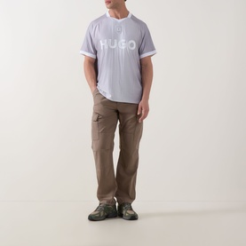 Model wearing Hugo Dwild Logo T-Shirt in light/pastel green with stripe print, styled with khaki cargo trousers and grey trainers.