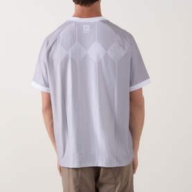 Model wearing Hugo Dwild Logo T-Shirt in light pastel green, back view showing diamond print pattern and short sleeves, styled with khaki trousers