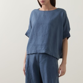 Model wearing Oska Lightweight Solid T-Shirt in blue linen with round neckline and short sleeves, styled with matching blue wide-leg trousers.
