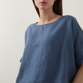 Model wearing Oska Lightweight Solid T-Shirt in blue linen, featuring a round neckline and relaxed short-sleeve silhouette.