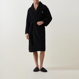 Model wearing Paul Smith Access Zebra Logo Robe in black, shawl collar, wrap front with belt, styled with navy slippers