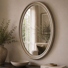 Mindy Browne Luca Framed Mirror in gold, oval shape with ornate PU frame, styled on a neutral wall with decorative vase and bowl.
