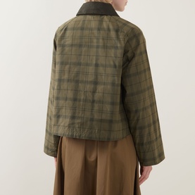 Model wearing Barbour Beadnell Tartan Cropped Jacket in green tartan with dark corduroy collar, rear view, styled with wide-leg trousers.