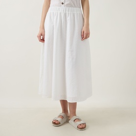 Model wearing Barbour Melody Broderie Anglaise Skirt in white, midi length with elasticated waist and flared silhouette, styled with beige sandals.