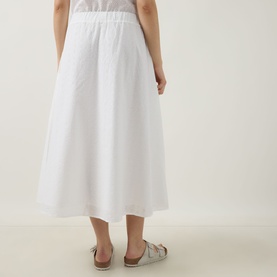 Model wearing Barbour Melody Broderie Anglaise Skirt in white, midi length with flared silhouette and elasticated waist. Styled with silver flat