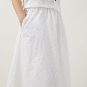 Model wearing Barbour Melody Broderie Anglaise Skirt in white, midi length with elasticated waist, flared silhouette and embroidered cotton fabric.