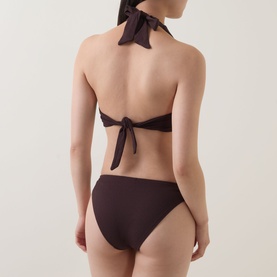 Model wearing Jets Bikini Brief in Chocolate, shown from behind with matching halterneck bikini top tied at neck and back