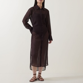 Model wearing Jets Belted Beach Shirt Dress in chocolate sheer fabric with collar, long sleeves and high-low hem, styled with tan strappy sandals