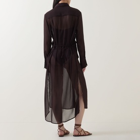 Model wearing Jets Belted Beach Shirt Dress in chocolate sheer fabric with self-tie belt, high-low hem; styled with strappy flat sandals.