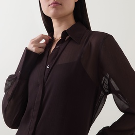 Model wearing Jets Belted Beach Shirt Dress in chocolate, showing sheer long sleeves with check detail cuffs and button fastening, styled with gold