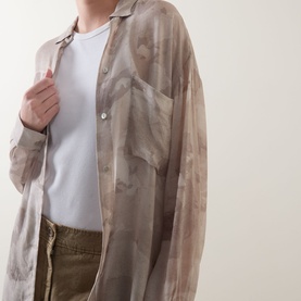 Model wearing Transit Tonal Printed Longline Shirt in sand, semi-sheer with tonal print, styled over a white T-shirt with olive trousers