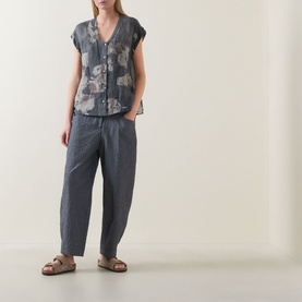 Model wearing Transit Abstract Print Blouse in Blu Slate with grey tapered trousers and tan sandals