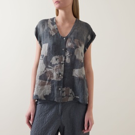 Model wearing Transit Abstract Print Blouse in Blu Slate, V-neck with cap sleeves and front buttons, styled with matching grey trousers