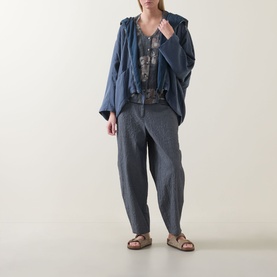Model wearing Transit Abstract Print Blouse in Blu Slate, styled with a blue oversized jacket and grey wide-leg trousers with tan sandals.