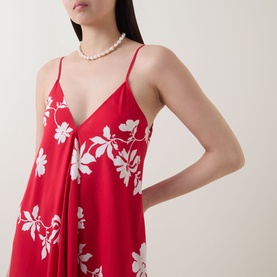 Model wearing Seafolly Mayflower Scarf Dress in Cosmo Red with white floral print, V-neckline and spaghetti straps, styled with pearl necklace