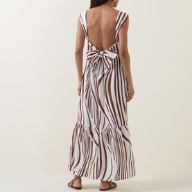 Model wearing Seafolly Striped Tiered Dress in Cocoa, showing low-cut open back with adjustable tie fastening and tiered maxi skirt