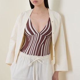 Model wearing Seafolly cocoa striped swimsuit styled with cream blazer and white drawstring trousers