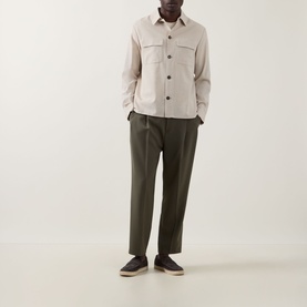 Model wearing Slowear Silk Flap Pocket Overshirt in stone with dark olive trousers and navy loafers