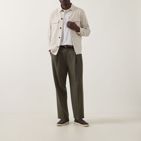 Model wearing Slowear Silk Flap Pocket Overshirt in stone with olive trousers, white tee, and dark loafers.