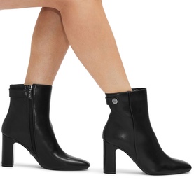 Model wearing Carvela Jackpot Wide Fit Ankle Boots in black synthetic leather, pointed toe, block heel, gunmetal hardware side button detail