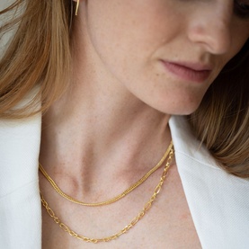 Model with Juvi Heavy Curb Chain Necklace in gold vermeil, layered with a fine link chain necklace. Gold drop earring visible