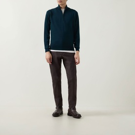 Model wearing John Smedley Tapton Extra Fine Knit Half-Zip Sweater in Richardson green, styled with dark trousers and brown leather shoes.