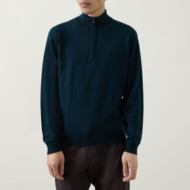 Model wearing John Smedley Tapton Extra Fine Knit Half-Zip Sweater in Richardson green with ribbed trims, styled with dark trousers.