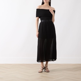 Model wearing Selected Femme Millie Pliss&eacute; Pleated Skirt in black, midi length with sheer pleated finish, styled with black off-shoulder top and