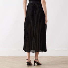 Model wearing Selected Femme Millie Pliss&eacute; Pleated Skirt in black, midi length with pliss&eacute; finish, styled with black heeled mules.