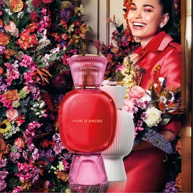 BVLGARI Allegra Fiori D'Amore Eau de Parfum 100ml, red and pink bottle with ribbed base, shown with smiling model in floral setting