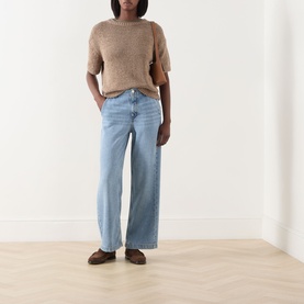 Model wearing Marc O Polo Solid Knit Top in taupe with crew neck and short sleeves, styled with light blue wide-leg jeans and brown loafers.