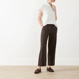 Model wearing Marc O Polo Textured Polo Shirt in Light Grey with cap sleeves, styled with dark brown wide-leg trousers and loafers.