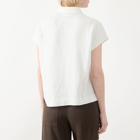 Model wearing Marc O Polo Textured Polo Shirt in light grey, shown from behind, with short cap sleeves and straight hem, styled with brown trousers.