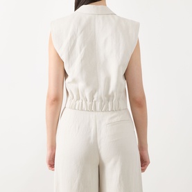 Model wearing Marc O Polo Double-Breasted Cropped Waistcoat in beige, back view showing elasticated rear detail, styled with matching wide-leg