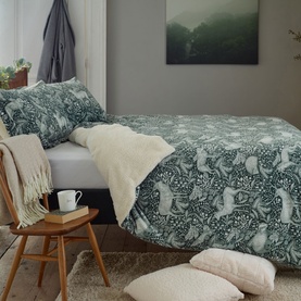 Deyongs Woodland Folk Fleece Duvet Set in Dark Sage green, featuring forest animal print, styled on a double bed with cream throw