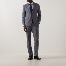 Model wearing grey check suit, styled with light blue shirt, navy tie and black Oxford shoes
