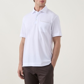 Model wearing Zegna white linen cashmere silk polo shirt with chest pocket, styled with brown trousers