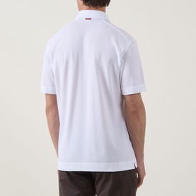 Model wearing Zegna white polo shirt, rear view, linen cashmere silk blend, short sleeves, paired with dark trousers